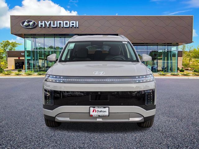A white Hyundai IONIQ 9 parked head-on outside the Dalton Hyundai National City showroom